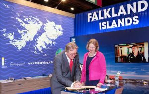 El legislador en representación de un circuito de Liverpool Peter Dowd firma el libro de visitas del stand de las Falklands   