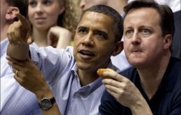 Barack Obama y el ex primer ministro David Cameron compartiendo panchos durante un partido de la NBA    