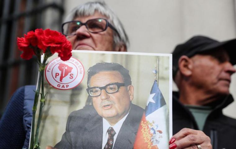 Una mujer sostiene un retrato en homenaje al presidente chileno Salvador Allende