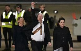 Assange, de 52 años, desembarcó del avión ejecutivo con traje oscuro, camisa blanca y corbata, y con el puño en alto 