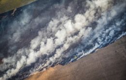 Un incendio forestal durante la sequía de 2023 es combatido por un avión fumigador en Rocha, al este de Uruguay. Foto: Sebastián Astorga Rostani.
