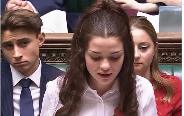 La joven Alexia Davies se dirige a sus pares ‘parlamentarios’ desde el podio tradicional de debate del parlamento británico 