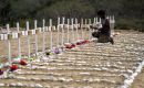 Un trabajador pinta las tumbas de v&iacute;ctimas no identificadas del terremoto del 24 de junio. Foto: Miguel Medina / AFP