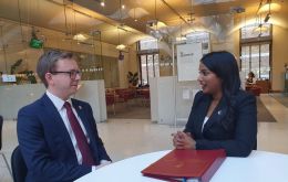 La ministra Uma Kumaran y el diputado Jack Ford mantienen una conversaci&oacute;n tras la intervenci&oacute;n de ella en el Parlamento.