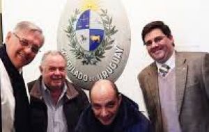 El grupo de legisladores junto al escudo del viejo Consulado de Uruguay en las Islas 