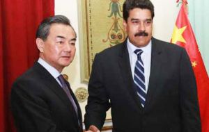 El presidente venezolano con el canciller chino Wang Yi (D)