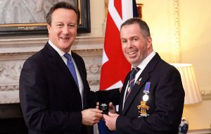 El primer ministro Cameron haciendo entrega de la medalla del Atlántico Sur a uno de los tantos veteranos que fueron recibidos en Downing Street