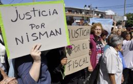 Numerosas personas recibieron con aplausos y flores los restos y llevaban carteles de “Justicia por Nisman” y banderas argentinas con un crespón negro
