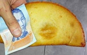 El usuario de Reddit “Victorinox126” compartió en la red social la imagen de un billete de dos bolívares que usa como servilleta para comer una empanada.