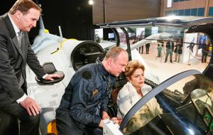 La presidenta Rousseff intenta ingresa a la cabina de un caza bombardero Gripen, durante su visita a la fábrica Saab 