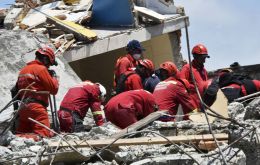 Socorristas ayudados por perros entrenados buscaban entre los escombros a las personas que continúan atrapadas tras el peor sismo en Ecuador en 40 años