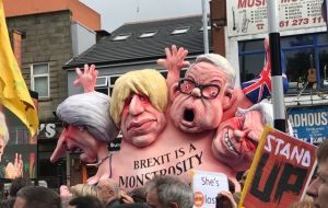 La caricatura gigante de May, en una lucha imposible con los miembros de su gabinete para ponerle el calcetín de la Union Jack al “monstruo” del Brexit