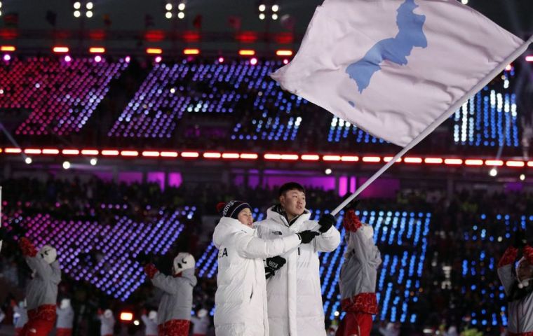 Los casi 150 deportistas de ambos países, 22 de ellos de Corea del Norte, dieron la vuelta al estadio detrás de una bandera unificadora con el mapa de la península