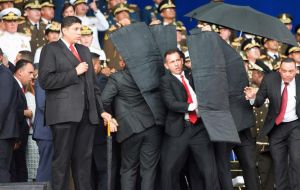 Maduro es protegido por sus guardaespaldas en el palco oficial previo al inicio de la ceremonia militar 