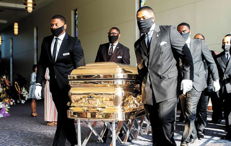 El féretro dorado con los restos mortales fue ingresado a una iglesia de Houston, Texas, por varios ciudadanos negros con traje y barbijo negros