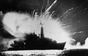 Foto icónica de HMS Antelope alcanzado por aviones argentinos al momento que explotaran las bombas y tomara fuego