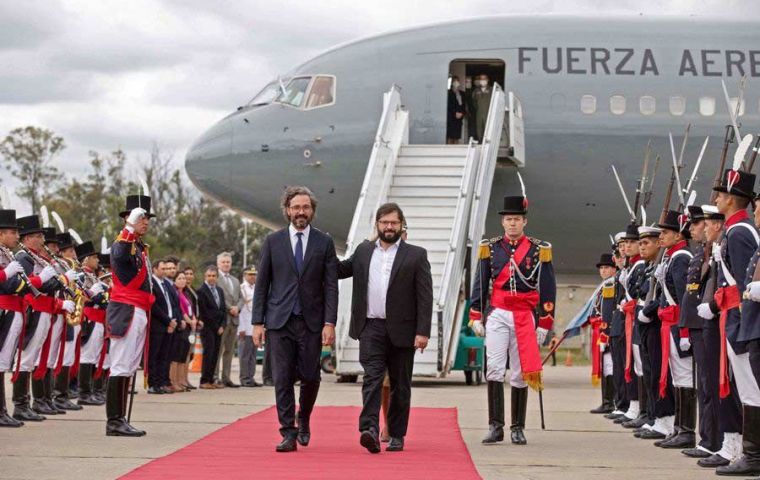 El Presidente Gabriel Boric (C-R) camina junto al Ministro de Asuntos Exteriores argentino Santiago Cafiero a su llegada a Buenos Aires