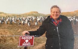Harold Briley con un cartel de un campo minado en las Falklands