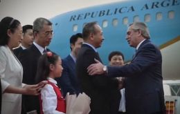 El presidente Fernández (d) fue recibido por funcionarios chinos a su llegada a Shanghai